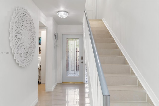 entryway featuring stairs and baseboards