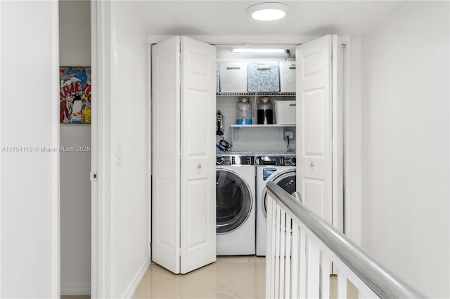 washroom featuring laundry area, washing machine and dryer, and light tile patterned flooring