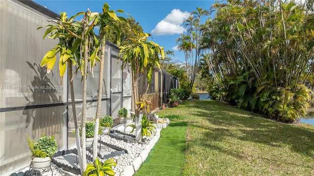 view of yard featuring a lanai and a water view