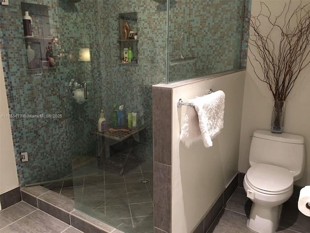 full bath featuring tile patterned flooring, toilet, and a walk in shower