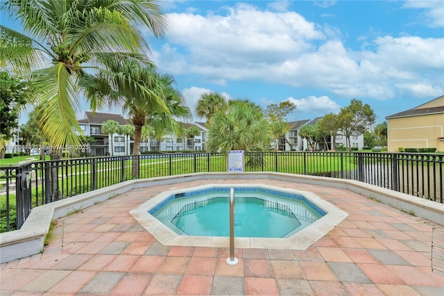 view of pool featuring a community hot tub, a residential view, and fence