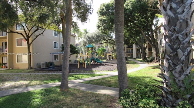 community jungle gym with a lawn and central air condition unit