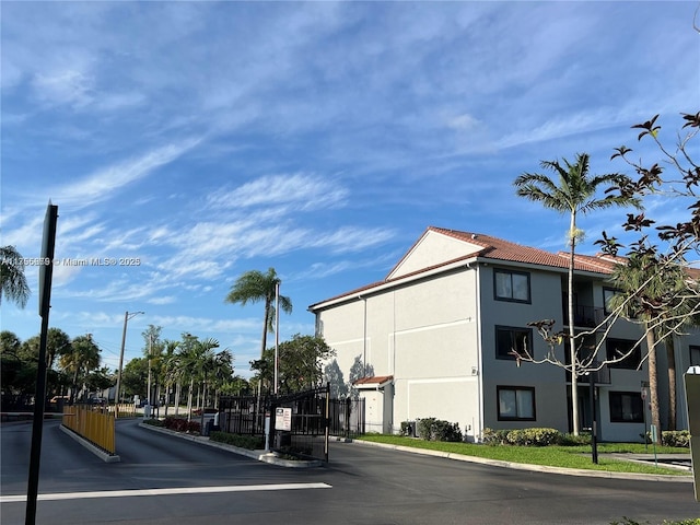 view of road with a gate, curbs, a gated entry, and street lights