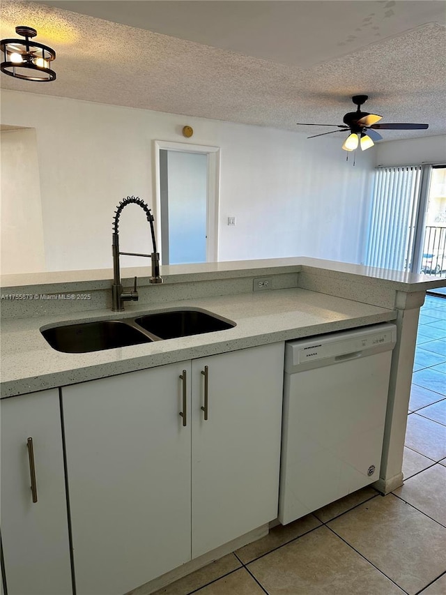 kitchen featuring dishwasher, light tile patterned floors, a textured ceiling, and a sink