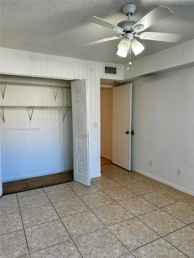 unfurnished bedroom featuring light tile patterned floors, a textured ceiling, a closet, and visible vents