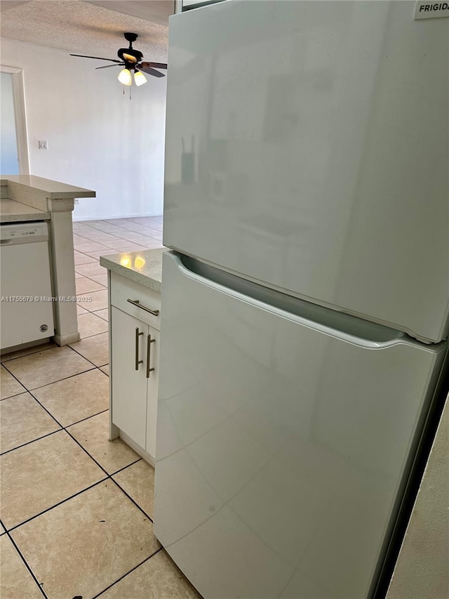 interior details featuring a ceiling fan, light countertops, white appliances, and white cabinets