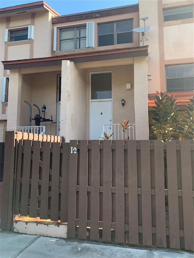 multi unit property featuring a fenced front yard and stucco siding