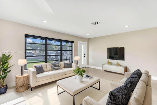 tiled living area with baseboards, visible vents, and recessed lighting