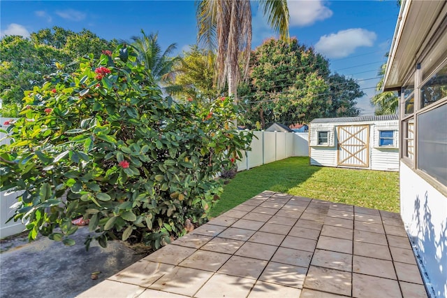 view of patio / terrace with a storage shed, a fenced backyard, and an outbuilding