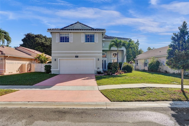 view of front of home with driveway, a tiled roof, fence, a front lawn, and stucco siding