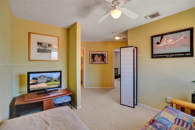 bedroom featuring a textured ceiling, carpet floors, visible vents, and baseboards