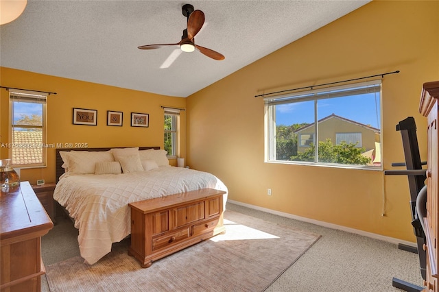 carpeted bedroom with multiple windows, vaulted ceiling, and a textured ceiling