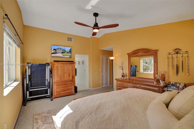 bedroom with light colored carpet, visible vents, vaulted ceiling, ceiling fan, and baseboards