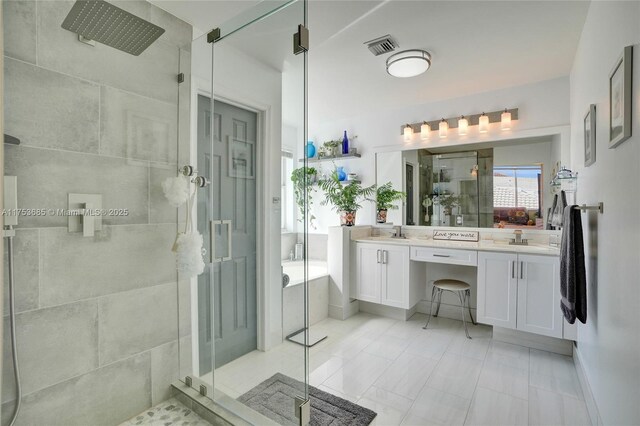 full bath featuring visible vents, a sink, a shower stall, and double vanity