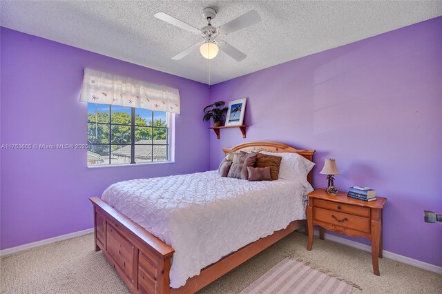 carpeted bedroom with a ceiling fan, baseboards, and a textured ceiling