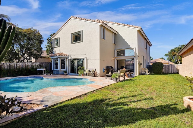 back of house with a fenced in pool, a patio, a lawn, a fenced backyard, and stucco siding