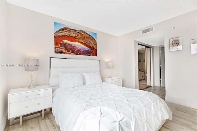 bedroom featuring light wood finished floors and visible vents