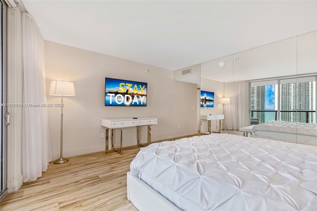 bedroom featuring wood finished floors, visible vents, and baseboards