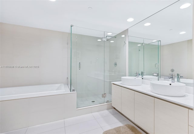 bathroom with double vanity, tile patterned floors, a sink, a shower stall, and a bath