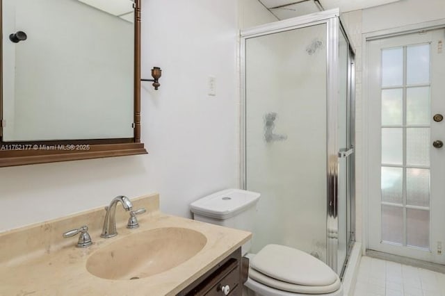 bathroom featuring toilet, a shower stall, and vanity