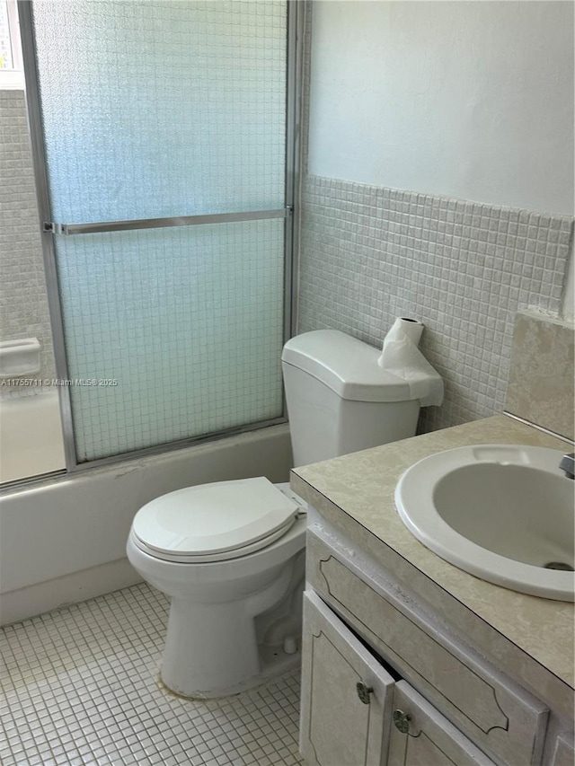 18555 NE 14th Ave Unit 502-B, Miami, FL 33179 - full bathroom featuring tile patterned flooring, enclosed tub / shower combo, tile walls, and vanity