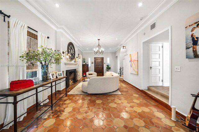 living room featuring visible vents, an inviting chandelier, crown molding, a fireplace, and recessed lighting