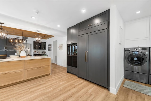 kitchen featuring washer / dryer, decorative light fixtures, light countertops, light wood-style floors, and recessed lighting