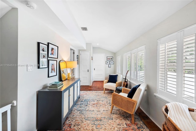 sitting room featuring visible vents, vaulted ceiling, and baseboards