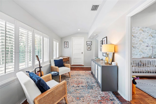 living area with lofted ceiling, visible vents, and baseboards