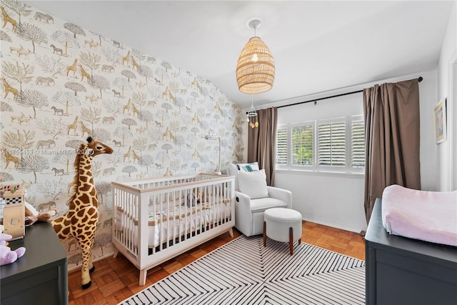 bedroom featuring wallpapered walls and a nursery area