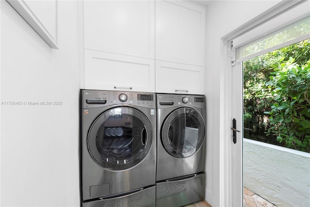 washroom featuring cabinet space and washing machine and clothes dryer