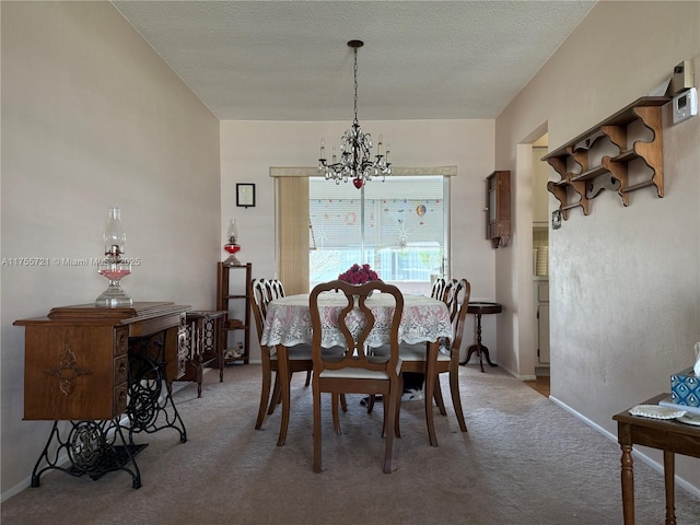 dining room with a textured ceiling, a notable chandelier, and light colored carpet