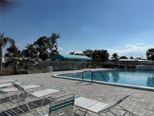 pool featuring fence and a patio