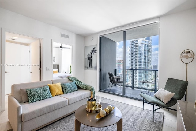 living area with a wall of windows, a view of city, and visible vents