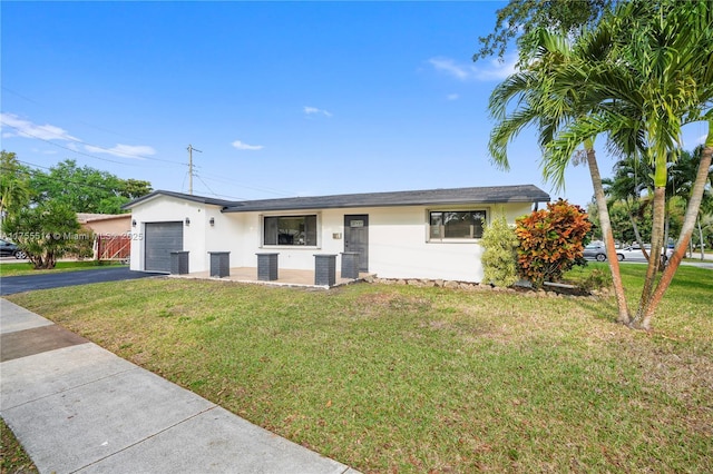 ranch-style house with an attached garage, a front yard, aphalt driveway, and stucco siding