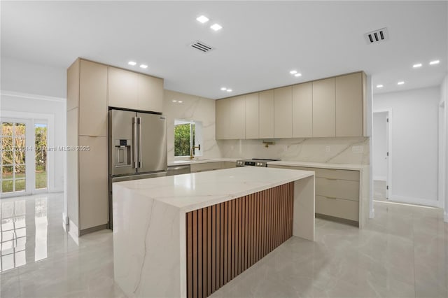 kitchen featuring cream cabinets, stainless steel appliances, visible vents, a healthy amount of sunlight, and modern cabinets