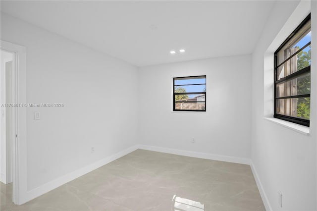 spare room featuring plenty of natural light, baseboards, and recessed lighting