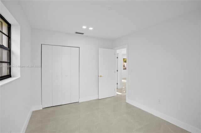 unfurnished bedroom featuring visible vents, baseboards, and a closet