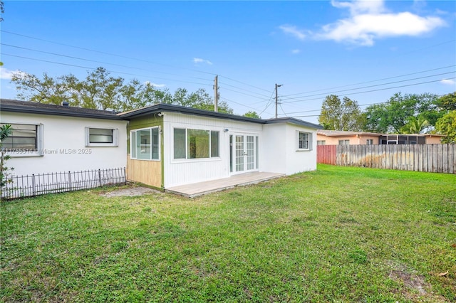 rear view of house featuring a yard and fence