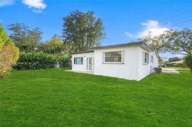 5280 SW 90th Ave, Cooper City, FL 33328 - rear view of house with stucco siding, a lawn, and central air condition unit
