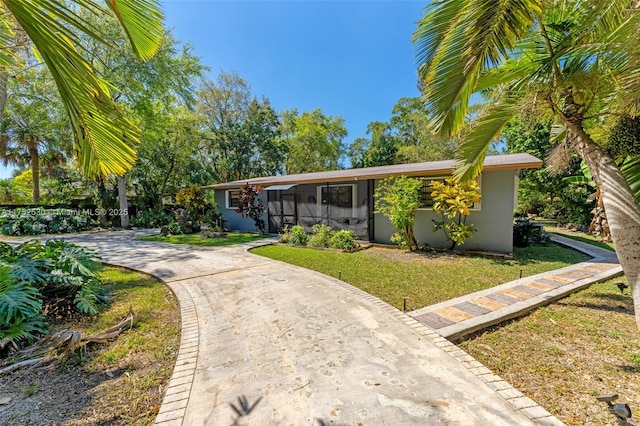 mid-century inspired home featuring a front lawn, concrete driveway, and stucco siding