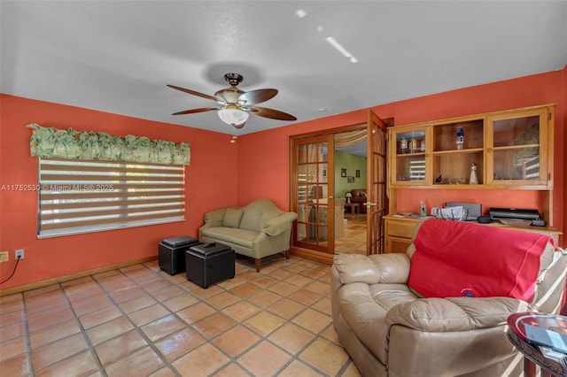 living area featuring light tile patterned floors and a ceiling fan