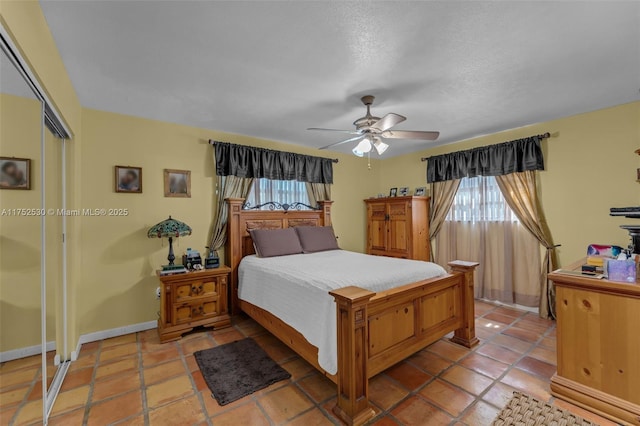 bedroom with ceiling fan, baseboards, a closet, and light tile patterned flooring