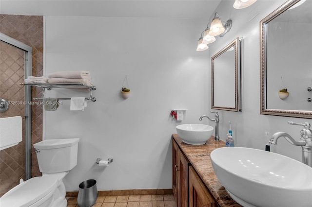 full bath featuring a stall shower, tile patterned flooring, a sink, and toilet