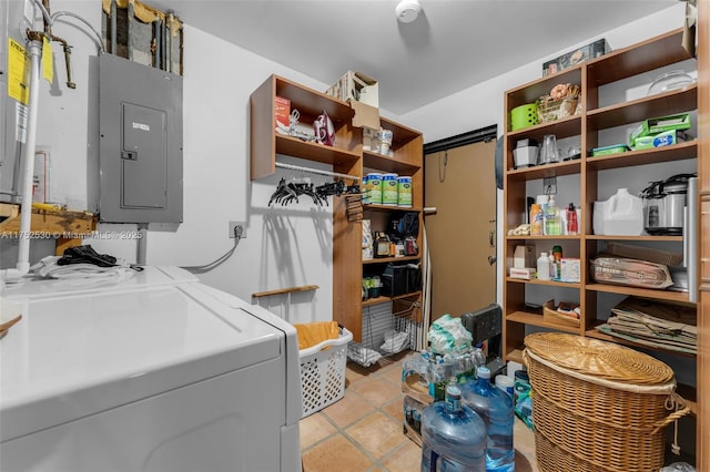 laundry area with laundry area, washing machine and dryer, electric panel, and light tile patterned floors