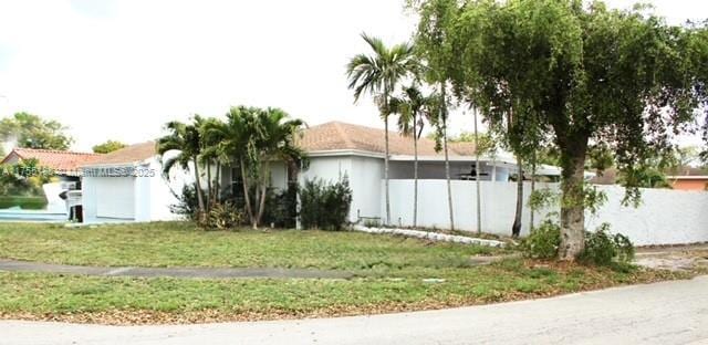 view of property exterior featuring a yard and fence