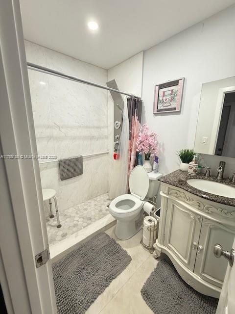 full bathroom with toilet, tile patterned floors, a shower stall, and vanity