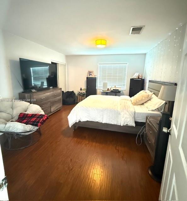 bedroom featuring visible vents and wood finished floors