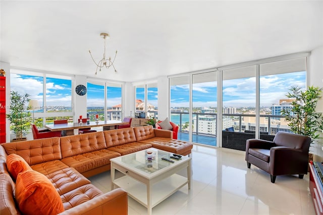 living area featuring light tile patterned floors, a view of city, a chandelier, and a wall of windows