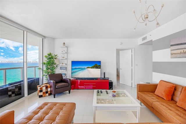 living area featuring a notable chandelier, a water view, visible vents, tile patterned floors, and expansive windows